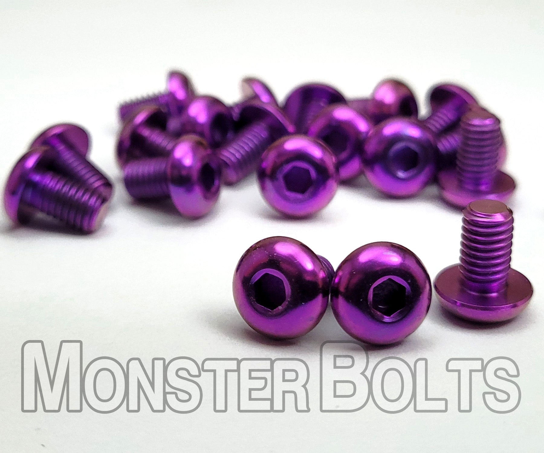 Purple anodized titanium screws arranged in a fan layout — solid color finish showing surface consistency