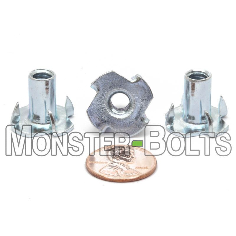 1/4-20 x 9/16" Zinc Plated 4-Prong T-Nuts on a white background shown with US Penny.
